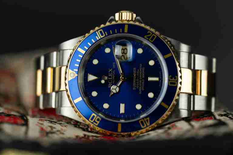Taucheruhr in Stahl und Gold mit blauer Luenette