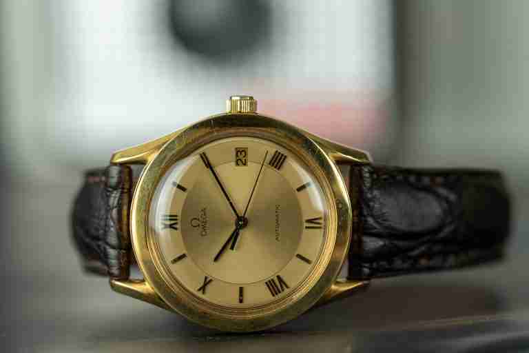 Goldene Vintage-Armbanduhr mit dunklem Lederband