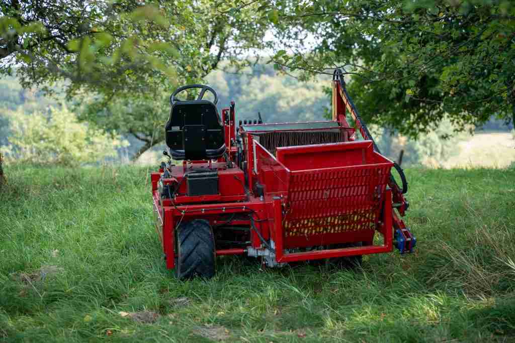 Rote Erntemaschine fuer Streuobst auf einer Wiese